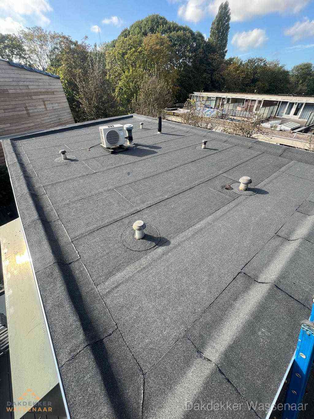 Plat dak met bitumen en brandgereedschap van dakdekkersbedrijf in Wassenaar